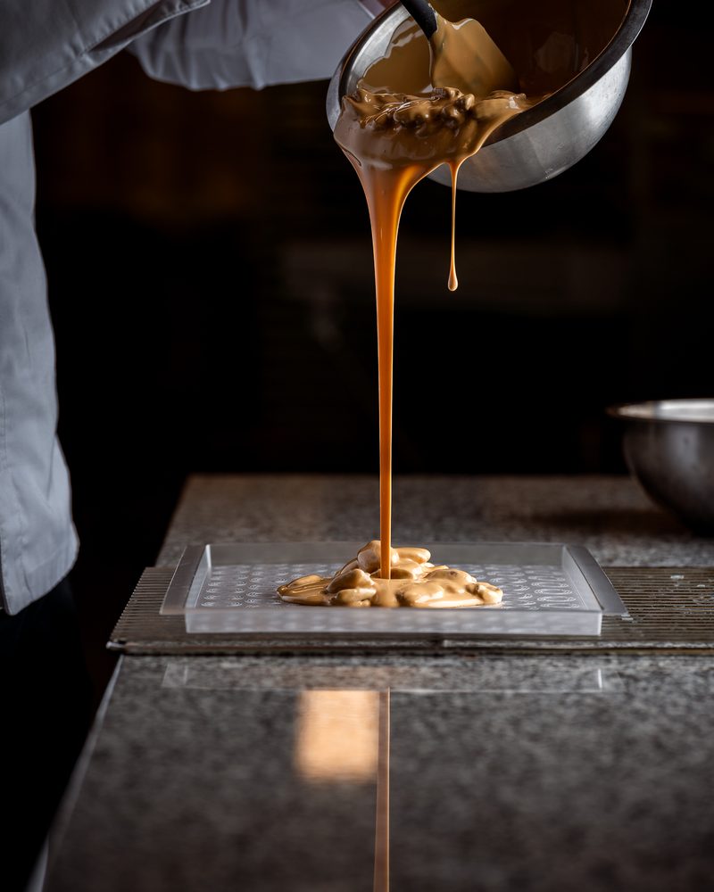 Caramel being poured into a mould in a chocolate workshop